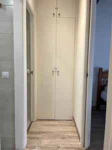 um corredor com duas portas brancas num quarto em Envalira Vacances - Etoile duplex ideal familia con vista a pistas em Pas de la Casa