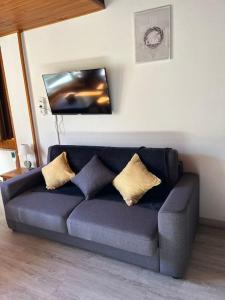 ein blaues Sofa mit Kissen im Wohnzimmer in der Unterkunft Envalira Vacances - Etoile duplex ideal familia con vista a pistas in Pas de la Casa