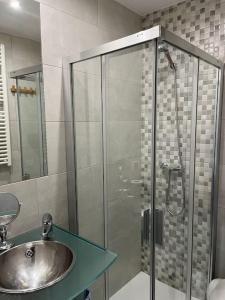 uma casa de banho com um lavatório e uma cabina de duche em vidro. em Envalira Vacances - Etoile duplex ideal familia con vista a pistas em Pas de la Casa