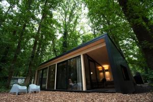 Une petite maison noire au milieu d'une forêt dans l'établissement Buitenplaats Petersburg, à Arnhem