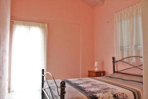 een slaapkamer met een bed en een raam bij Zeus and Hera Apartments in Nikiana
