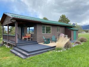 Cabaña pequeña con terraza de madera en un campo en Pine Creek Cabin Livingston Montana en Livingston