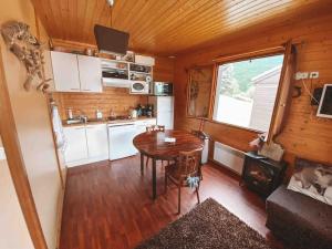 a kitchen with a table in a tiny house at Chalet cosy Ignaux - Ax les thermes in Ignaux