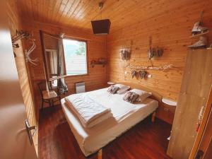 a bedroom with a bed in a wooden room at Chalet cosy Ignaux - Ax les thermes in Ignaux