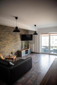 a living room with a couch and a brick wall at Róża Wiatrów 2 in Giżycko