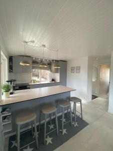 a kitchen with a large counter with stools around it at Modern cottage in Årsta Havsbad Stockholm, Sweden in Årsta Havsbad