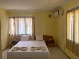 a bedroom with a bed with bows on it at Морска База Венера in Tsarevo