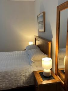 a bedroom with a bed and a table with a lamp at Cheerful 3 bedroom cottage in central location in Ambleside
