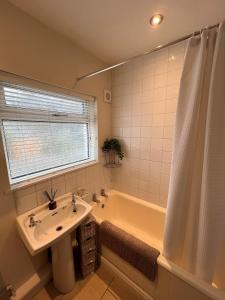 a bathroom with a sink and a tub and a window at Cheerful 3 bedroom cottage in central location in Ambleside