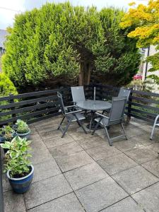 a table and chairs on a patio with plants at Cheerful 3 bedroom cottage in central location in Ambleside