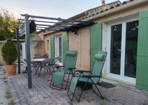 patio con sedie, tavolo e pergolato di Gîte des Laquets a Sérignan-du-Comtat
