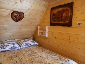 een slaapkamer met een bed in een blokhut bij Domek przy skalniaku in Biały Dunajec