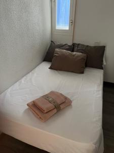 Una cama blanca grande con una toalla. en Apartamento Lara, en La Herradura