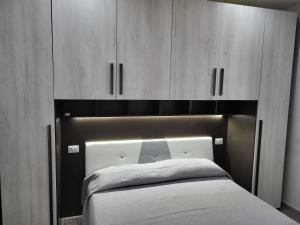 1 dormitorio con 1 cama con armarios de madera en Il bacio del sole, en Agropoli