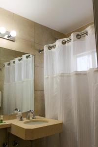 a bathroom with a shower curtain and a sink at Collins Hotel in Miami Beach