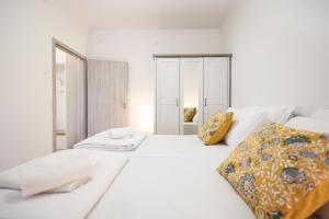 a white bed with a yellow pillow on it at Mathilda's apartment in Zadar