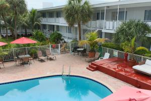 einen Pool vor einem Hotel mit Stühlen und Sonnenschirmen in der Unterkunft Collins Hotel in Miami Beach