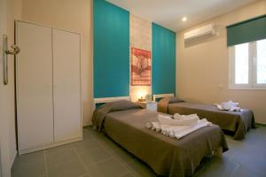 two beds in a room with blue walls at Seaside, relaxing family house with playground! Villa Lavrys 3 in Marathi