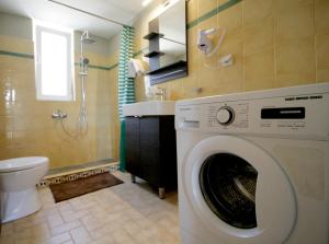 a washing machine in a bathroom with a toilet at Seaside, relaxing family house with playground! Villa Lavrys 3 in Marathi