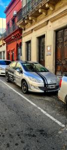 ein Auto, das auf einem Parkplatz neben einem Gebäude parkt in der Unterkunft Montevideo Port Hostel in Montevideo