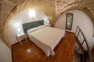 スペッキアにあるAlSalento Villa De Donnoのレンガの壁に大きなベッドが備わるベッドルーム1室が備わります。