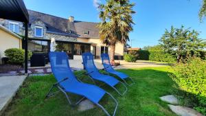 vier blaue Stühle im Gras im Garten in der Unterkunft Villa Excallibur, aux portes de Brocéliande in Carentoir