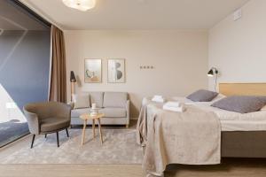 a hotel room with a bed and a chair at Marina Chalets Studios by Hiekka Booking - sisältää liinavaatteet ja loppusiivouksen in Kalajoki
