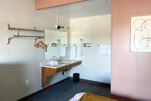 a bathroom with a sink and a mirror at The Benson Motel - Benson, MN - US-12 HWY in Benson