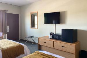 a hotel room with a tv on top of a dresser at The Benson Motel - Benson, MN - US-12 HWY in Benson