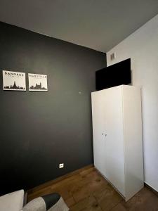 Zimmer mit einem weißen Schrank und einem TV an der Wand in der Unterkunft eM Apartment 6 in Kattowitz
