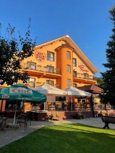 a hotel with tables and chairs in front of a building at Pensiunea Roua Muntilor in Vadu Crişului