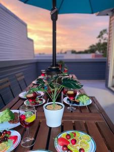 a wooden table with plates of food and wine glasses at THE ROOFTOP OASIS in Philadelphia