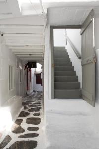 New Apartment in the heart of Mykonos town - 2 في مدينة ميكونوس: ممر فارغ مع درج في مبنى