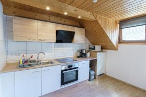 a kitchen with white appliances and a wooden ceiling at Ferienwohnungen Pham in Cochem