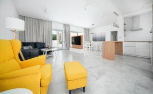 a living room with a yellow chair and a kitchen at Perla Luxury Apartment in Vodice