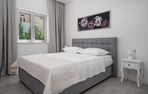 a bedroom with a large bed with white sheets and pillows at Perla Luxury Apartment in Vodice