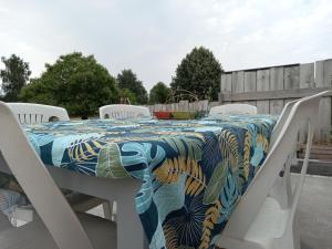 stół z białymi krzesłami i ścierką stołową w obiekcie Maison cocooning à 20 min des plages w mieście Cabariot