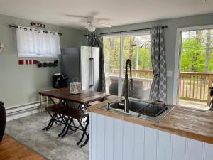 Pulaski的住宿－Cozy LAKE ONTARIO WATERFRONT Breathtaking Views!，厨房配有水槽、木桌和餐桌。