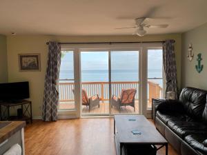- un salon avec un canapé et une vue sur l'océan dans l'établissement Cozy LAKE ONTARIO WATERFRONT Breathtaking Views!, à Pulaski