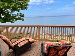 two chairs on a deck with a view of the ocean at Cozy LAKE ONTARIO WATERFRONT Breathtaking Views! in Pulaski