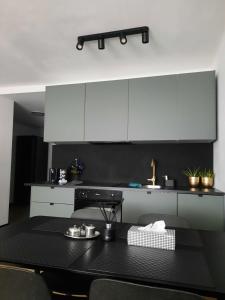 a kitchen with white cabinets and a black table at GOLD&BLACK OŚWIĘCIM CENTRUM in Oświęcim