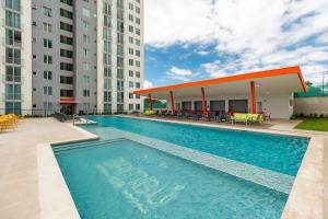 a swimming pool in front of two tall buildings at Boho Chic, Apart- condo cerca de SJO Intl airport in Barrial