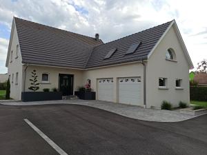 een groot wit huis met een garage bij Charmant sudio aux portes de Colmar in Durrenentzen