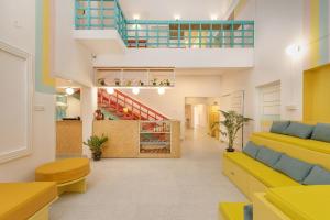 un vestíbulo con muebles amarillos y una escalera en Locul Midtown-Indiranagar, en Bangalore