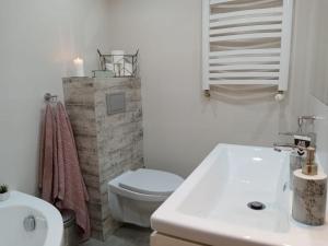 biała łazienka z toaletą i umywalką w obiekcie Apartament Ostoja w mieście Mrągowo
