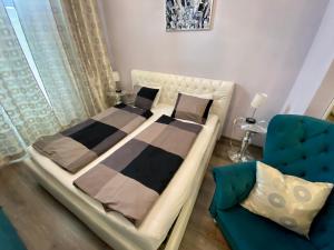 a bedroom with two beds and a blue couch at Kings main square Apartment - AC - Balcony - Coffee Machine - Washer - Kitchen- Parking in Poprad