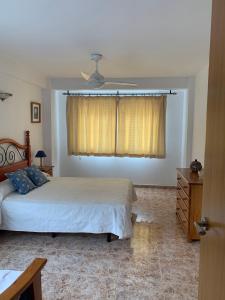 um quarto com uma cama e uma ventoinha de tecto em Apartamento vacacional Jávea em Xàbia