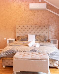 a bedroom with a large bed with a tufted headboard at Delux Apartmani Požarevac in Požarevac