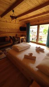 two beds in a wooden room with a large window at ELASYA BUNGALOV in Rize