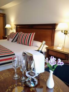 a hotel room with a bottle of wine and glasses on a table at Scala Hotel Buenos Aires in Buenos Aires